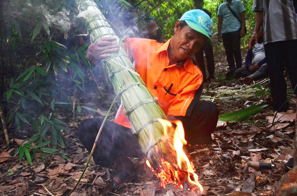 Hardin, pencari madu dari Desa Tawanga, Kecamatan Uluiwoi, Kabupaten Kolaka Timur, Sulawesi Tenggara sedang mempersiapkan obor yang menghasilkan asap sebagai pengusir lebah dari sarangnya. Tak seperti peternak lebah pada umumnya, mereka tidak menggunakan alat pelindung dari sengatan lebah, hanya mengandalkan asap tersebut. Foto: Wahyu Chandra